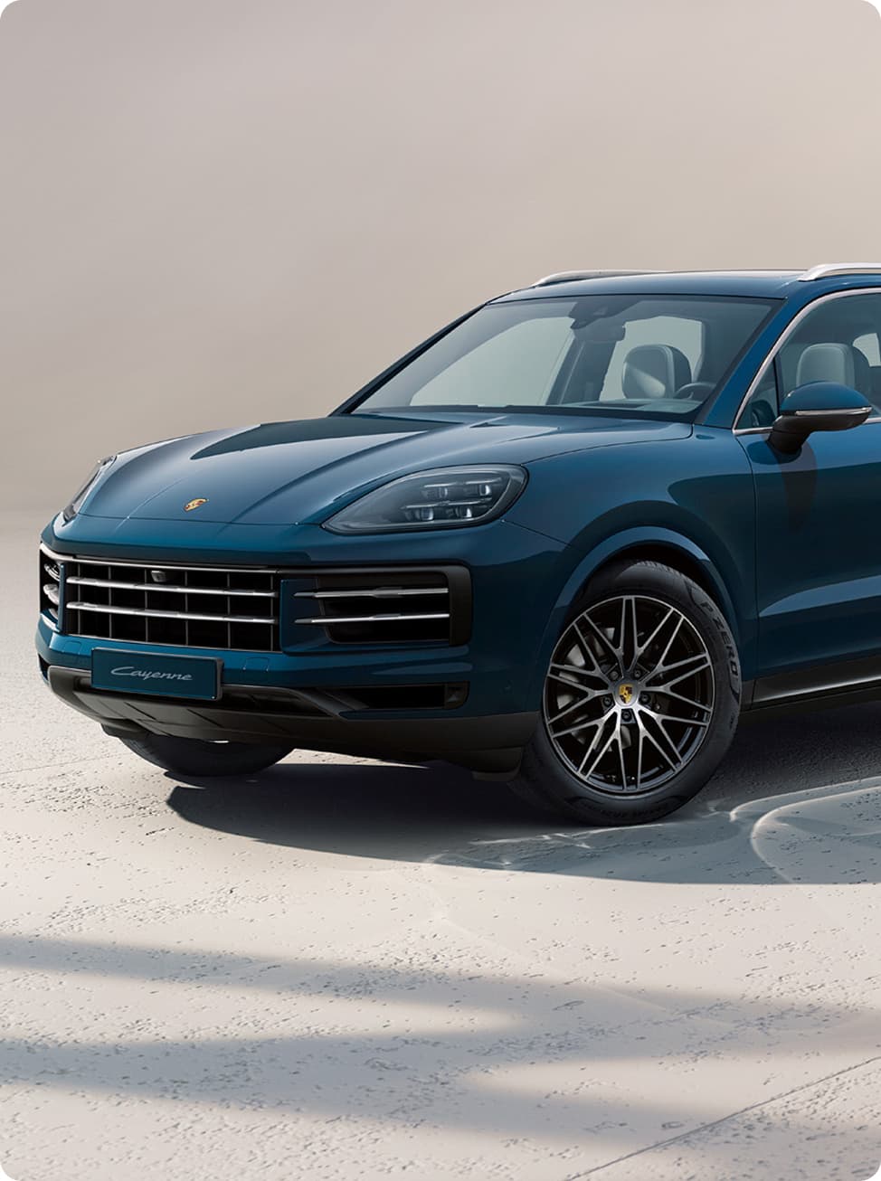 A Porsche Cayenne driving on an open road.